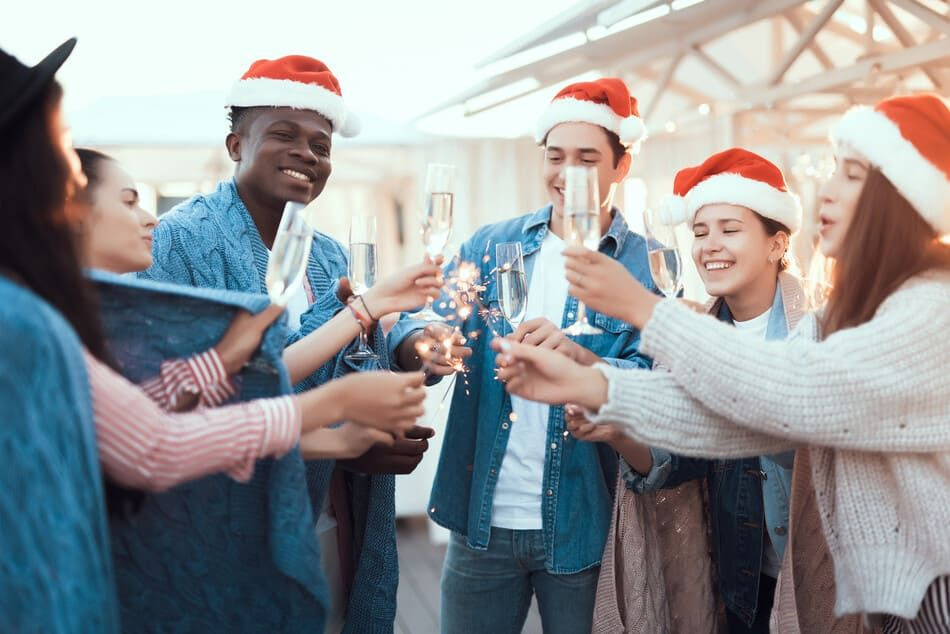 personas con gorros de navidad brindando